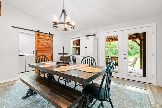 6170 Oberlin Rd, Amherst, OH 44001 - dining area featuring a barn door, light wood-style flooring, french doors, washing machine and clothes dryer, and vaulted ceiling