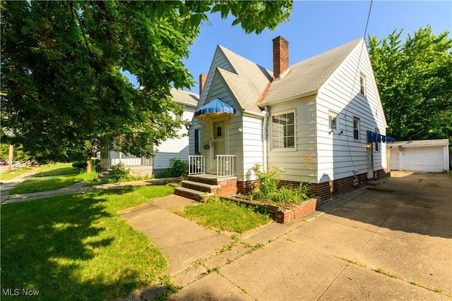 19005 Pawnee Ave, Cleveland, OH 44119 - bungalow-style house with an outbuilding, a chimney, a front yard, and roof with shingles