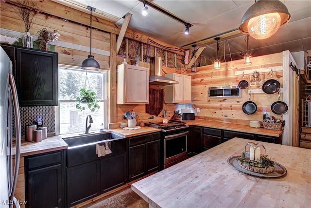 10770 W W Salem Rd, West Salem, OH 44287 - kitchen featuring stainless steel appliances, wooden walls, wall chimney range hood, wooden counters, and dark cabinetry