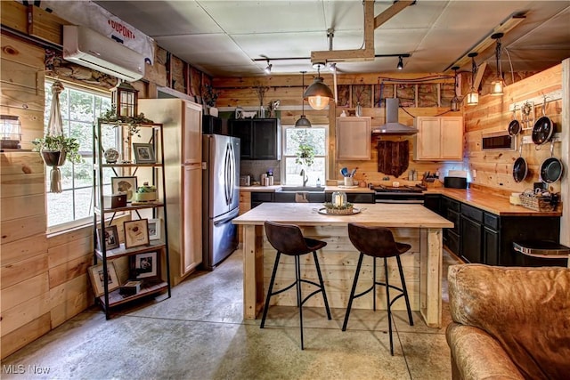 10770 W W Salem Rd, West Salem, OH 44287 - kitchen featuring wall chimney exhaust hood, freestanding refrigerator, wooden walls, butcher block countertops, and a breakfast bar area