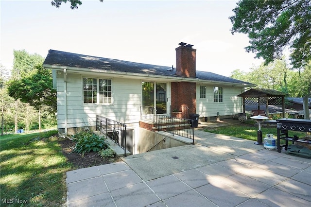 2948 Robin Hill Ln, Mogadore, OH 44260 - rear view of house featuring a chimney, a patio, a lawn, and a gazebo