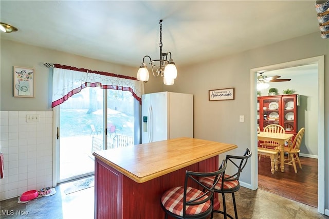 2948 Robin Hill Ln, Mogadore, OH 44260 - kitchen featuring white fridge with ice dispenser, healthy amount of natural light, a chandelier, and a breakfast bar area