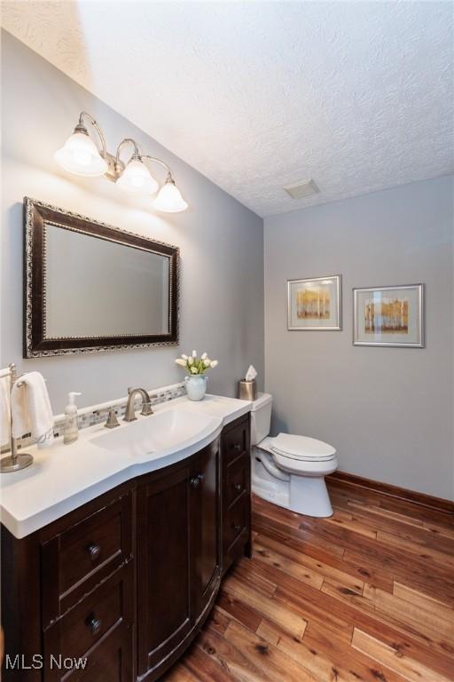 6252 Pebblebrook Ln, North Olmsted, OH 44070 - bathroom featuring hardwood / wood-style flooring, vanity, and a textured ceiling