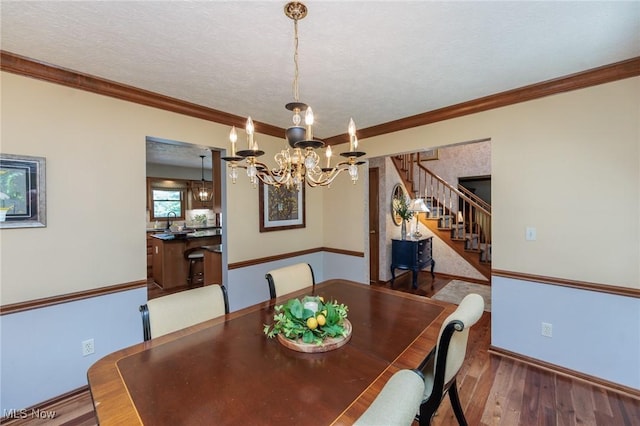 6252 Pebblebrook Ln, North Olmsted, OH 44070 - dining room with stairs, a chandelier, wood finished floors, crown molding, and a textured ceiling