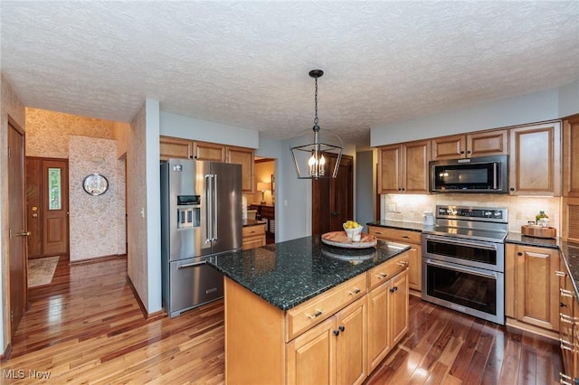 6252 Pebblebrook Ln, North Olmsted, OH 44070 - kitchen featuring appliances with stainless steel finishes, hardwood / wood-style flooring, a chandelier, a center island, and a textured ceiling