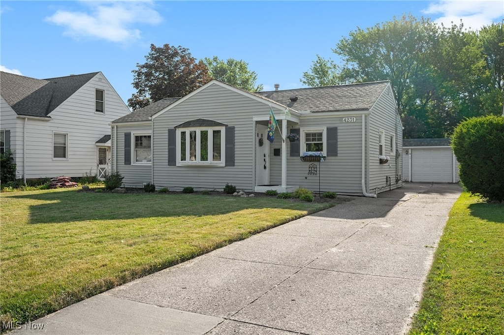 4231 W 220th St, Fairview Park, OH 44126 - bungalow featuring an outdoor structure, a shingled roof, a front yard, and driveway