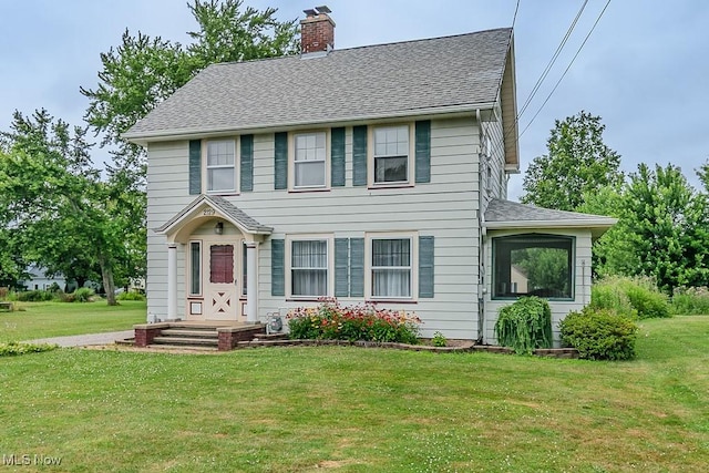 2129 E 41st St, Ashtabula, OH 44004 - colonial-style house with a chimney, a shingled roof, and a front yard