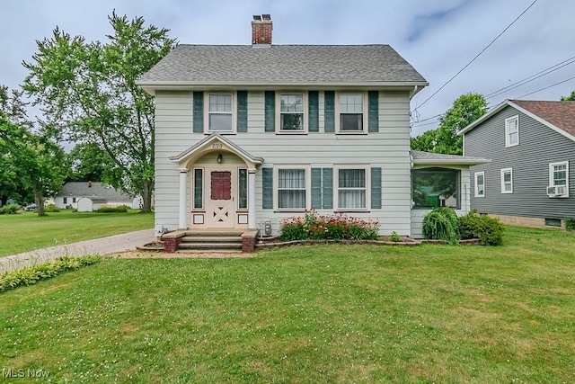 2129 E 41st St, Ashtabula, OH 44004 - colonial inspired home featuring a chimney, a front lawn, and cooling unit