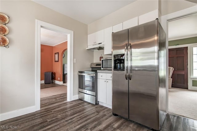 2129 E 41st St, Ashtabula, OH 44004 - kitchen with appliances with stainless steel finishes, under cabinet range hood, arched walkways, dark wood-style flooring, and white cabinets