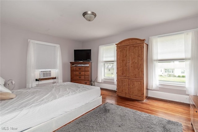 2129 E 41st St, Ashtabula, OH 44004 - bedroom featuring cooling unit, multiple windows, and wood finished floors