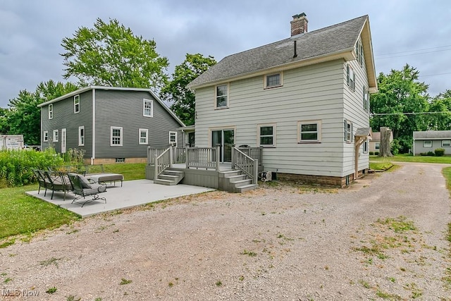 2129 E 41st St, Ashtabula, OH 44004 - rear view of property with a patio, a deck, a chimney, and a shingled roof