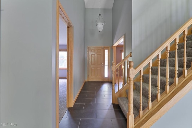 230 Clingan Rd, Struthers, OH 44471 - entryway with dark tile patterned floors, stairway, a high ceiling, and dark carpet