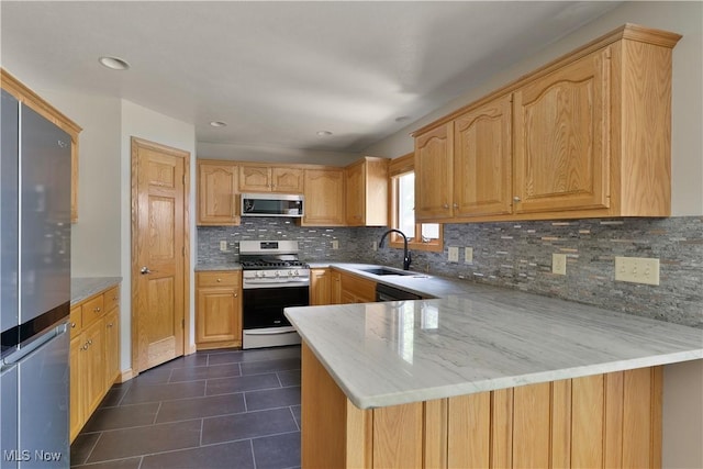 230 Clingan Rd, Struthers, OH 44471 - kitchen with appliances with stainless steel finishes, a peninsula, tasteful backsplash, dark tile patterned flooring, and light stone counters