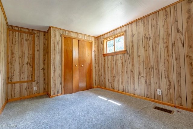 312 28th St SW, Canton, OH 44706 - unfurnished bedroom featuring a closet, carpet, and wood walls