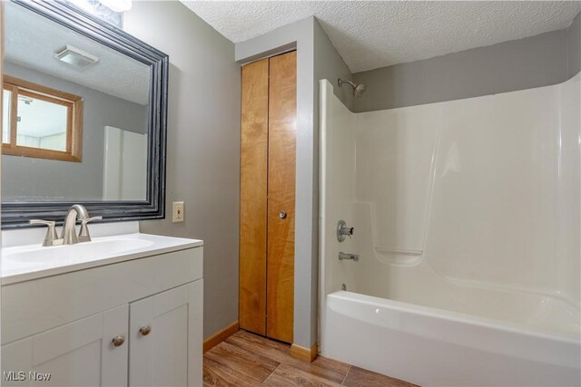 312 28th St SW, Canton, OH 44706 - full bath featuring wood finished floors, shower / tub combination, a textured ceiling, and vanity