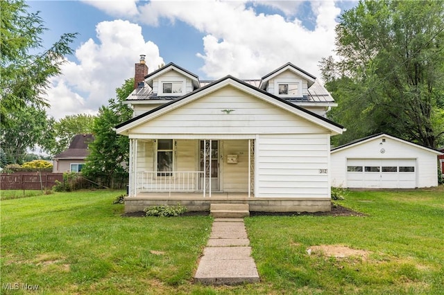 312 28th St SW, Canton, OH 44706 - view of front facade featuring covered porch, a garage, an outbuilding, and a chimney