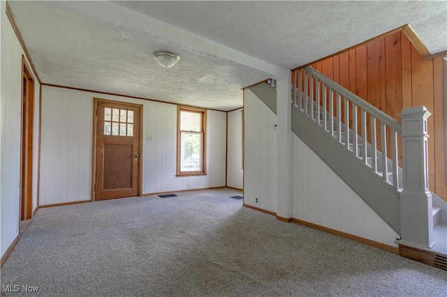 312 28th St SW, Canton, OH 44706 - foyer with a textured ceiling, carpet flooring, and stairway
