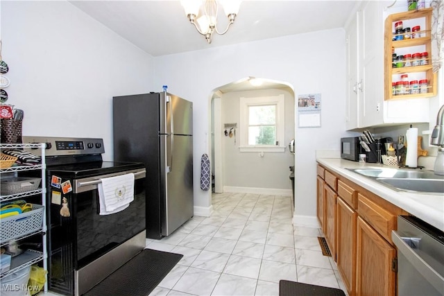 645 Saybolt Ave, Wooster, OH 44691 - kitchen with appliances with stainless steel finishes, light marble finish flooring, arched walkways, light countertops, and brown cabinetry