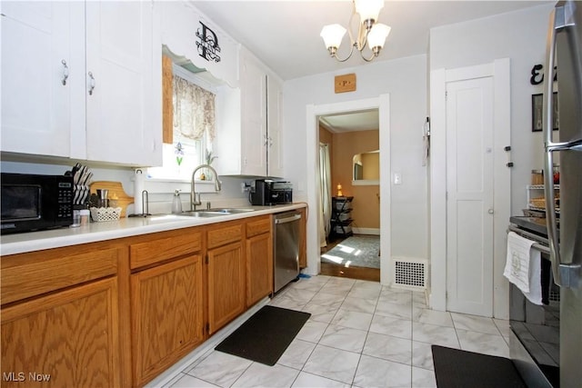 645 Saybolt Ave, Wooster, OH 44691 - kitchen featuring stainless steel appliances, light countertops, light marble finish floors, brown cabinets, and a chandelier