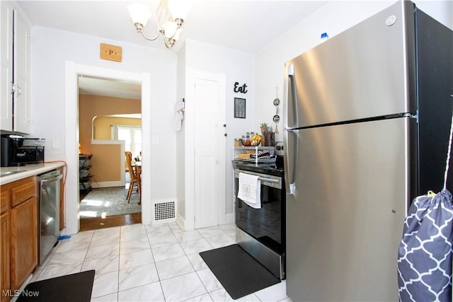 645 Saybolt Ave, Wooster, OH 44691 - kitchen with appliances with stainless steel finishes, brown cabinetry, light countertops, a chandelier, and light marble finish floors