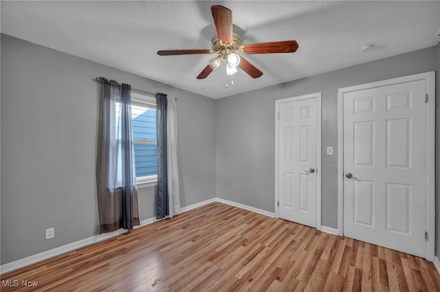 24850 Shoreview Ave, Euclid, OH 44123 - unfurnished bedroom featuring light wood finished floors, ceiling fan, and a textured ceiling