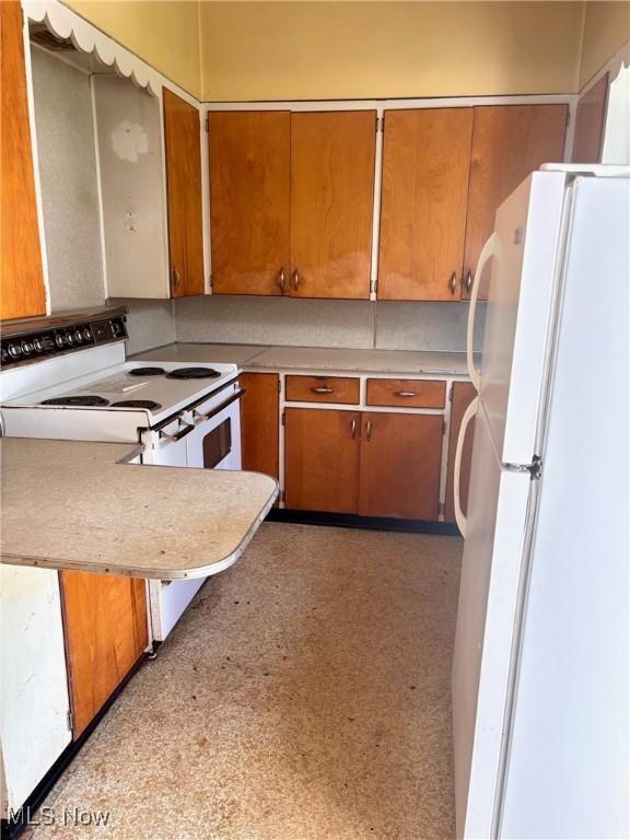 8 E Main St, New Concord, OH 43762 - kitchen featuring white appliances, light countertops, and brown cabinetry