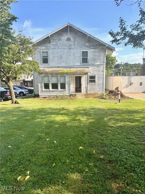 8 E Main St, New Concord, OH 43762 - rear view of house featuring a yard