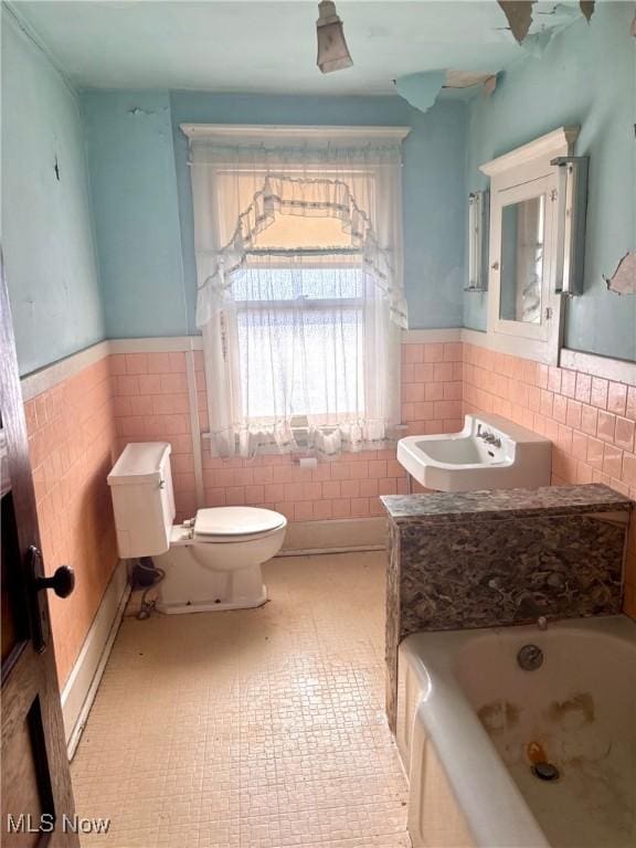 8 E Main St, New Concord, OH 43762 - full bathroom with tile walls, a tub with jets, a wainscoted wall, and tile patterned floors