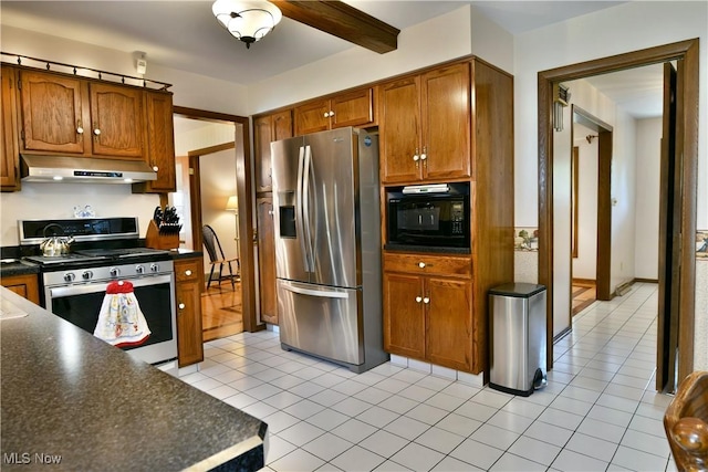 8518 Four Seasons Trl, Poland, OH 44514 - kitchen featuring stainless steel appliances, under cabinet range hood, dark countertops, brown cabinets, and light tile patterned floors