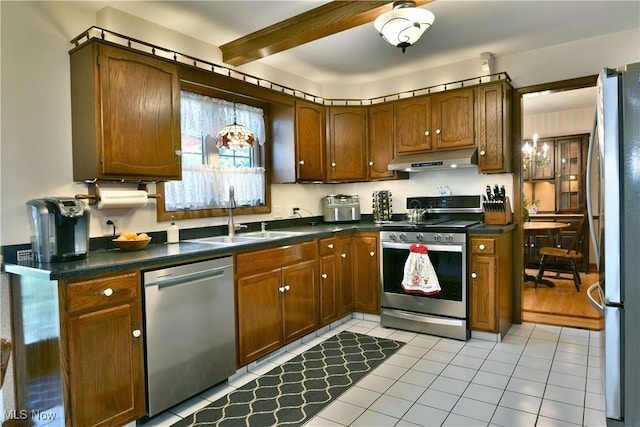 8518 Four Seasons Trl, Poland, OH 44514 - kitchen with stainless steel appliances, under cabinet range hood, beam ceiling, dark countertops, and light tile patterned flooring