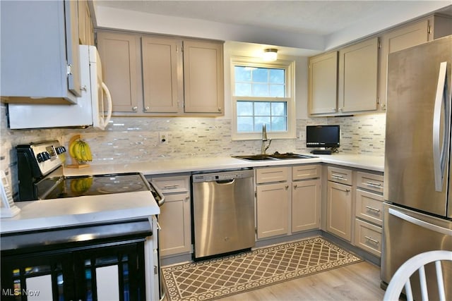 252 Greenbriar Dr, Cortland, OH 44410 - kitchen with stainless steel appliances, light countertops, tasteful backsplash, light wood finished floors, and gray cabinetry
