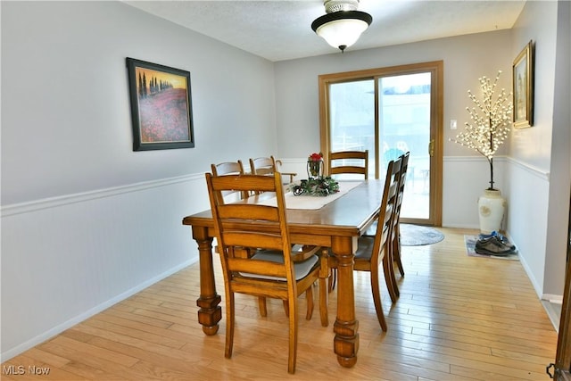 252 Greenbriar Dr, Cortland, OH 44410 - dining space with light wood-style flooring and a wainscoted wall