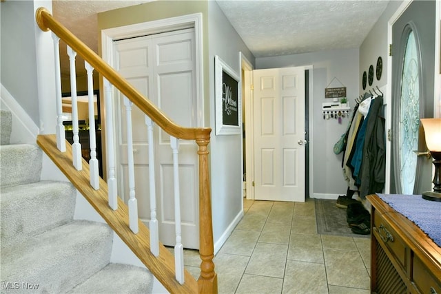 252 Greenbriar Dr, Cortland, OH 44410 - entryway featuring stairs, light tile patterned floors, and a textured ceiling