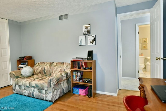 252 Greenbriar Dr, Cortland, OH 44410 - sitting room featuring wood finished floors, a textured ceiling, and crown molding