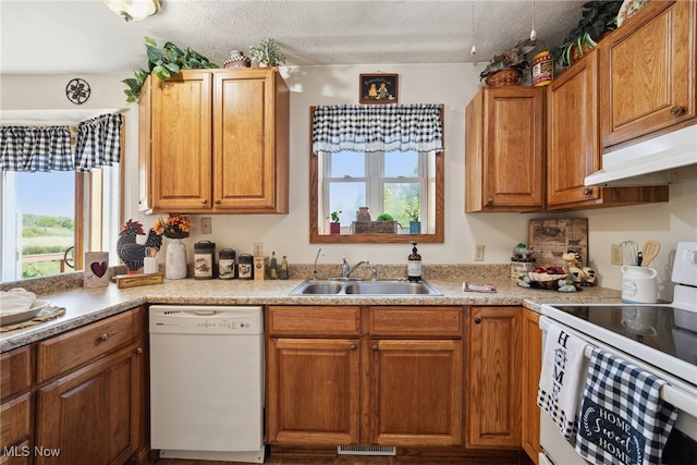 3823 Kyle Rd, Dorset, OH 44032 - kitchen featuring white appliances, healthy amount of natural light, light countertops, under cabinet range hood, and a textured ceiling