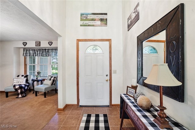 3823 Kyle Rd, Dorset, OH 44032 - entryway featuring healthy amount of natural light, a high ceiling, light colored carpet, and light tile patterned floors