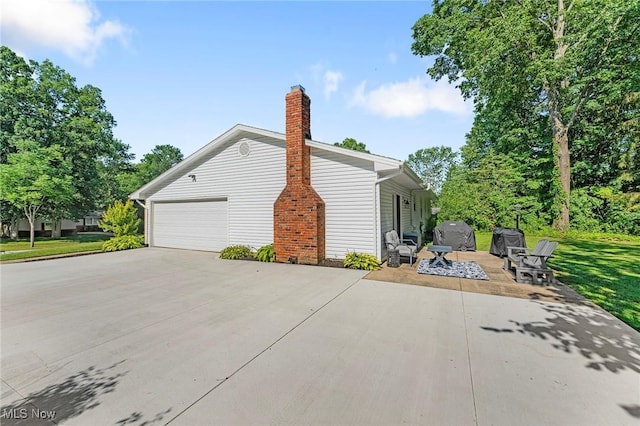 300 Chatham Dr, Aurora, OH 44202 - view of home's exterior featuring concrete driveway, a patio, and a chimney