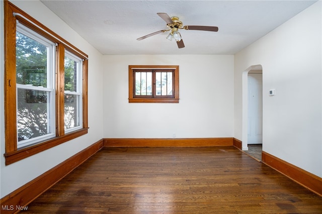 289-2891/2 E Baird Ave, Barberton, OH 44203 - empty room featuring dark wood-type flooring, healthy amount of natural light, arched walkways, and a ceiling fan