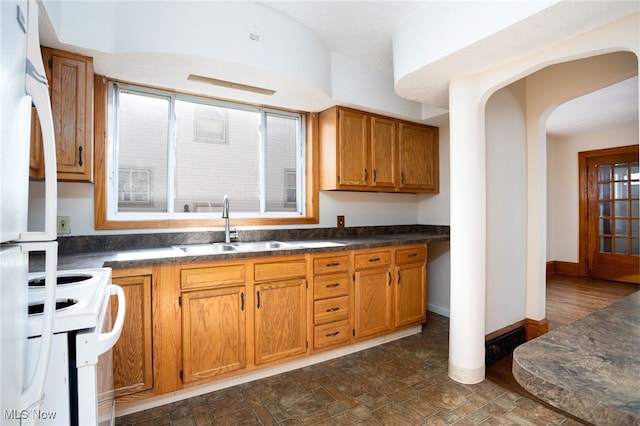 289-2891/2 E Baird Ave, Barberton, OH 44203 - kitchen featuring white appliances, dark countertops, arched walkways, and brown cabinetry