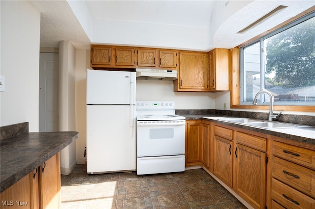 289-2891/2 E Baird Ave, Barberton, OH 44203 - kitchen with white appliances, under cabinet range hood, dark countertops, brown cabinetry, and stone finish floors
