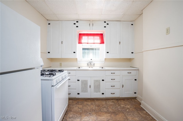 289-2891/2 E Baird Ave, Barberton, OH 44203 - kitchen with white appliances, a drop ceiling, white cabinetry, light countertops, and stone finish flooring