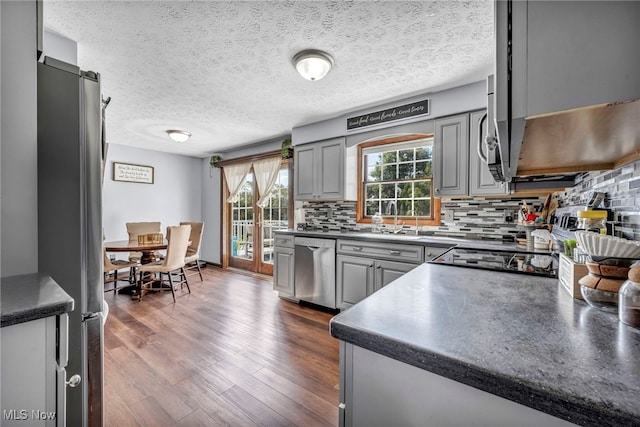 9827 Akron Rd, Rittman, OH 44270 - kitchen with stainless steel appliances, gray cabinetry, dark countertops, backsplash, and dark wood-type flooring