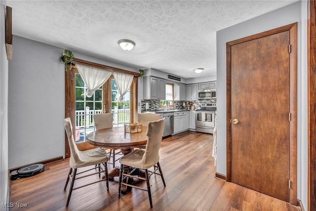 9827 Akron Rd, Rittman, OH 44270 - dining space featuring light wood-style flooring and a textured ceiling