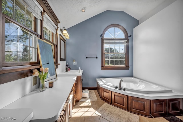 9827 Akron Rd, Rittman, OH 44270 - full bath featuring vanity, a bath, vaulted ceiling, tile patterned flooring, and a textured ceiling