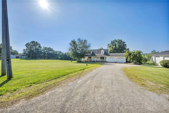 9827 Akron Rd, Rittman, OH 44270 - view of front facade featuring driveway, a garage, and a front lawn