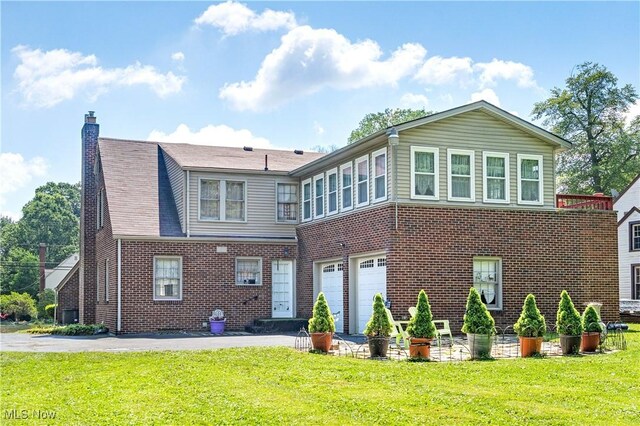 6100 Glenwood Ave, Boardman, OH 44512 - rear view of house with brick siding, a garage, and a yard
