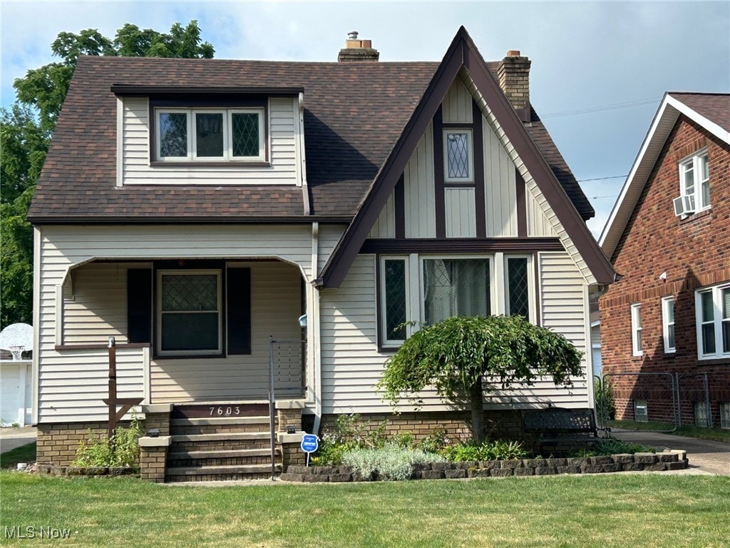 7603 Jameson Rd, Parma, OH 44129 - view of front facade featuring a chimney, a front yard, a porch, and roof with shingles