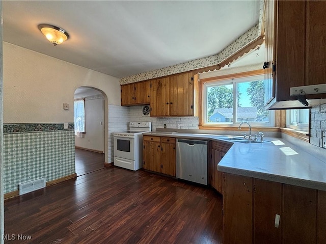 3109 Latimer Ave, Ashtabula, OH 44004 - kitchen with stainless steel dishwasher, white electric range oven, wallpapered walls, arched walkways, and plenty of natural light