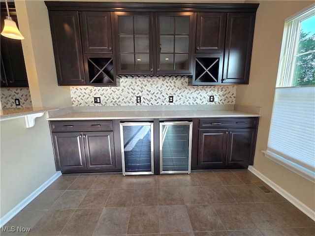 4312 Brooks Ct, Lorain, OH 44053 - bar area featuring wine cooler, decorative backsplash, and dark tile patterned flooring