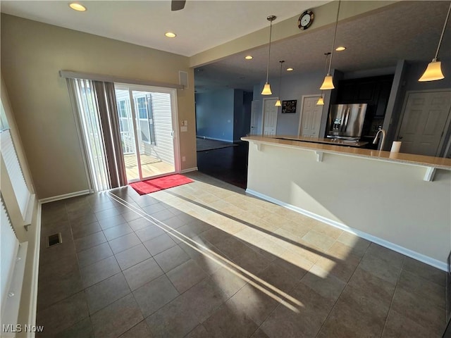 4312 Brooks Ct, Lorain, OH 44053 - kitchen featuring stainless steel refrigerator with ice dispenser, a breakfast bar area, dark tile patterned flooring, recessed lighting, and open floor plan
